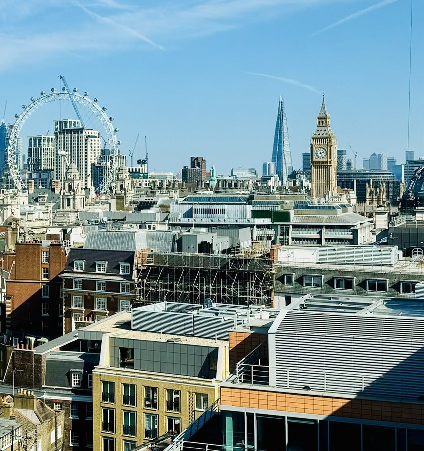 London skyline looking east over Westminster rooftops, with the Elizabeth Tower, the Shard and the City beyond
